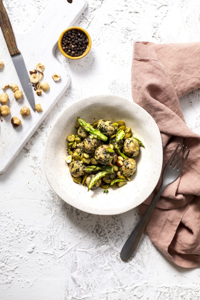 Gnocchi di pane raffermo, ricota e spinacini, conditi con asparagi all'olio di cocco e nocciole croccanti