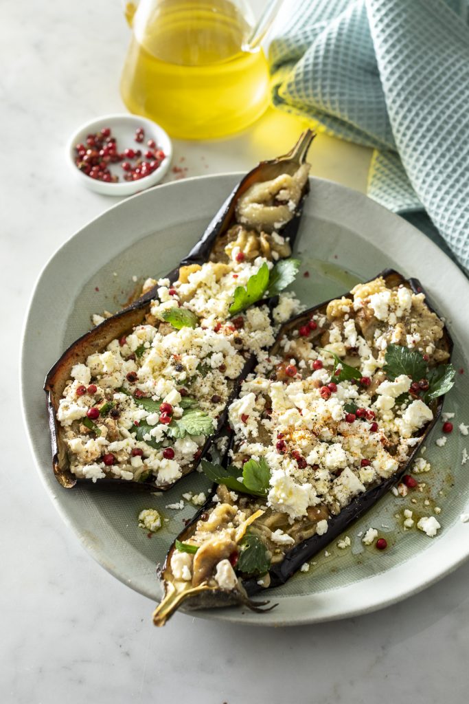 melanzane al forno ripiene con la polpa aromatizzata, feta e pepe rosa. Piatto finale. 